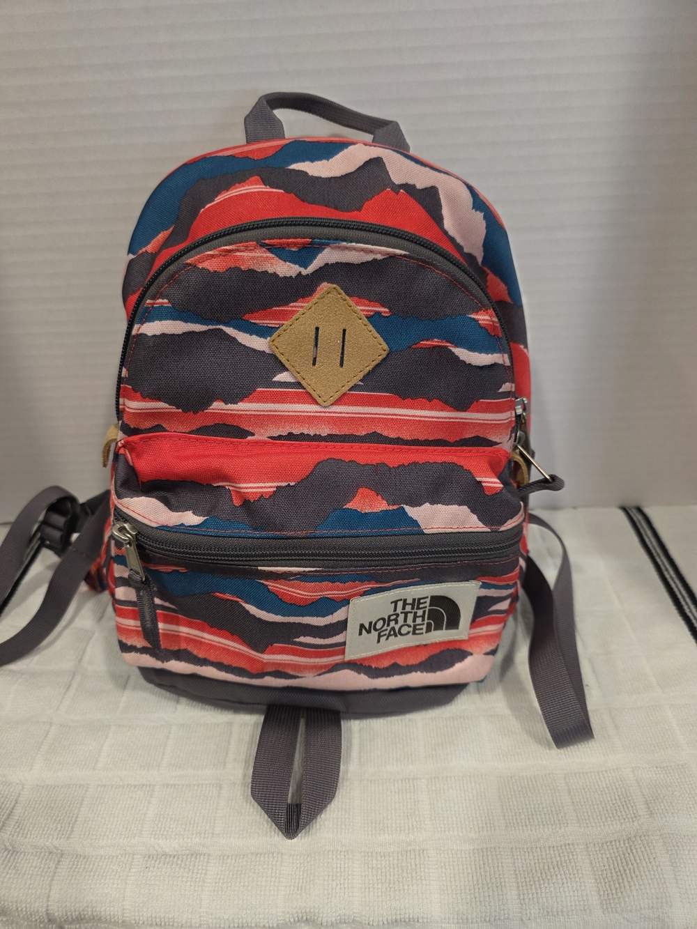 The North Face Mini Backpack in Red, Pink & Blue Wave Print